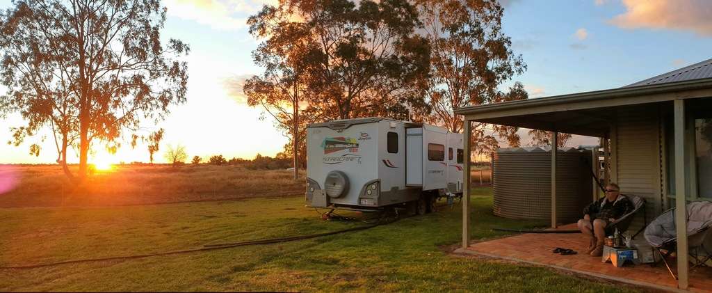Full Time Caravanning farm work as you travel. View from caravan of sunset and station