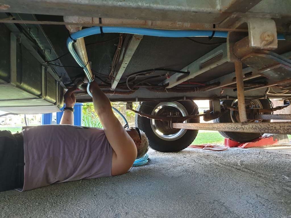 under caravan attaching hose to carry rainwater to main tanks automatically through WIFI