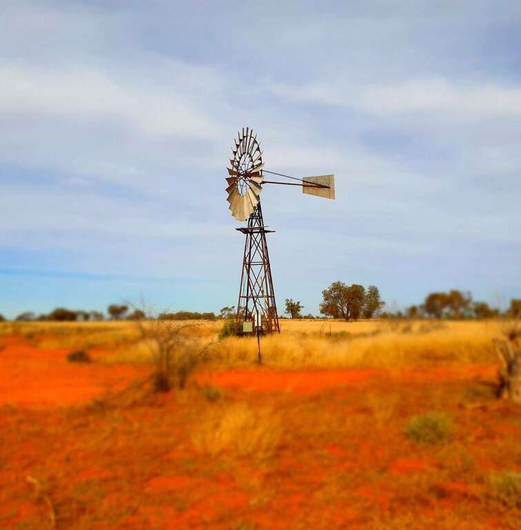 Full time caravanning finding farm work station work while travelling. old classic windmill on a farm with red dirt